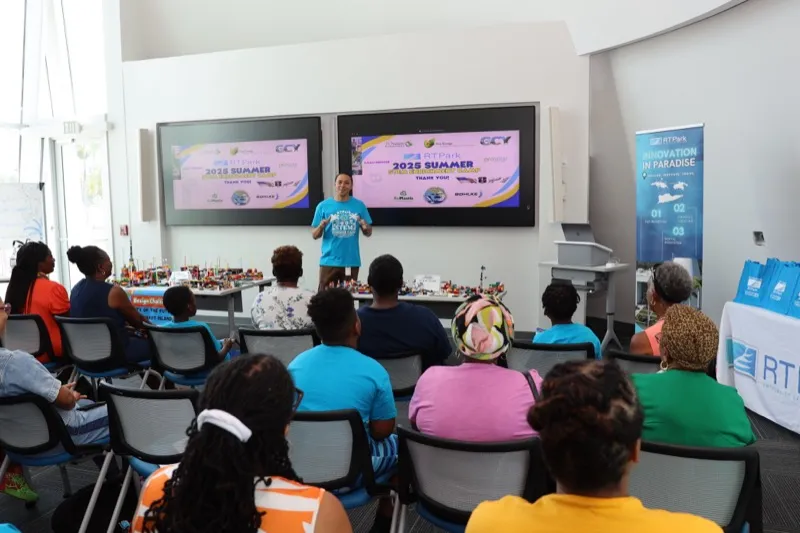Families seated for a STEM Summer Camp closing ceremony as a presenter speaks beside a thank-you slide.